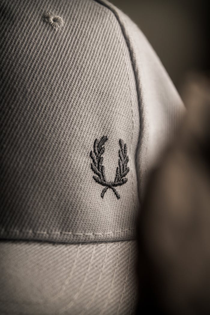 A detailed view of a cap with a classic olive branch embroidery, showcasing texture and design.